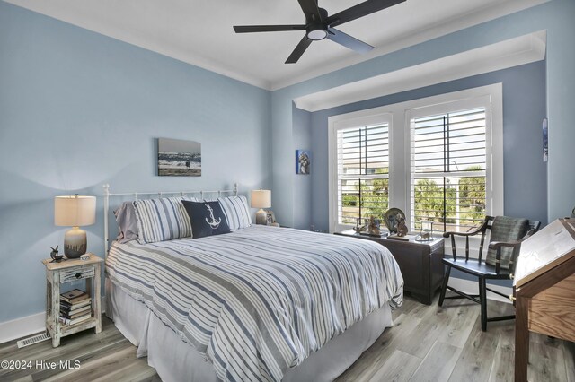 bedroom featuring ceiling fan, hardwood / wood-style floors, and ornamental molding