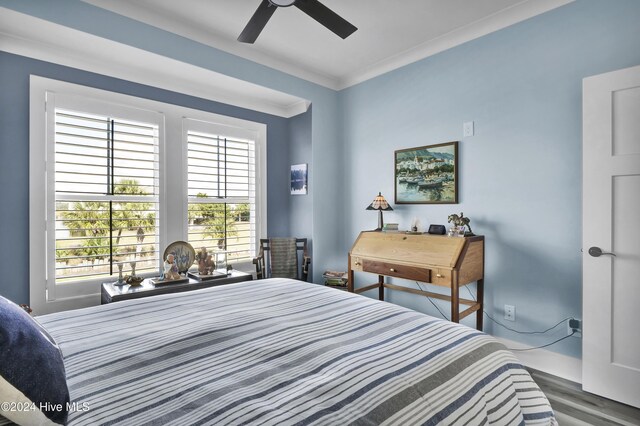 bedroom featuring hardwood / wood-style floors, ceiling fan, and crown molding