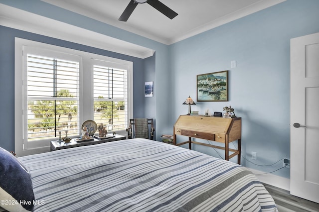 bedroom with a ceiling fan, crown molding, and wood finished floors