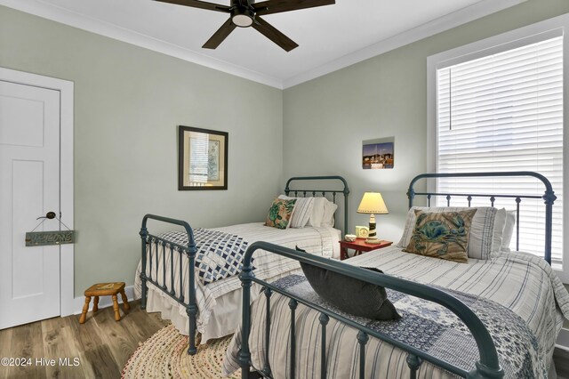 bedroom featuring wood-type flooring, ceiling fan, and ornamental molding