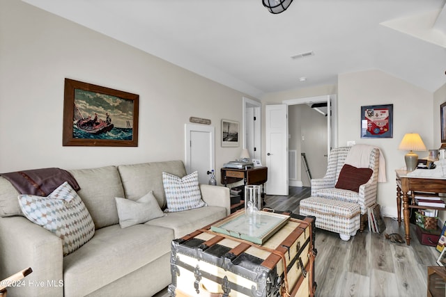 living room with vaulted ceiling and hardwood / wood-style flooring