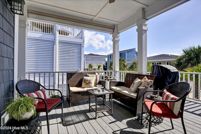 wooden terrace with a ceiling fan and outdoor lounge area