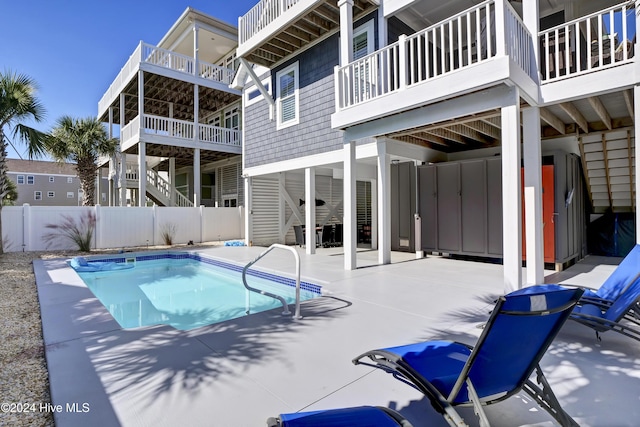 view of swimming pool featuring a fenced in pool, fence, stairway, and a patio