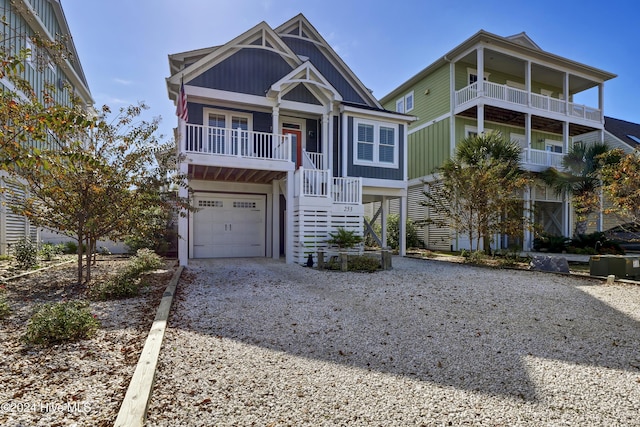 coastal home featuring a garage, driveway, stairway, and board and batten siding