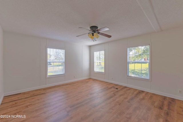 spare room featuring light hardwood / wood-style floors, a textured ceiling, and ceiling fan