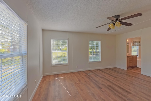 unfurnished room with a textured ceiling, wood-type flooring, and ceiling fan