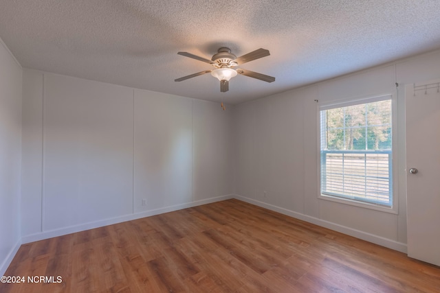 unfurnished room with ceiling fan, a textured ceiling, and hardwood / wood-style floors