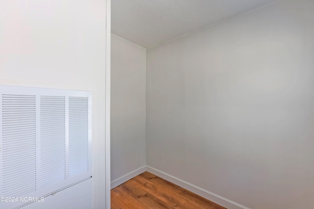 empty room with a textured ceiling and wood-type flooring