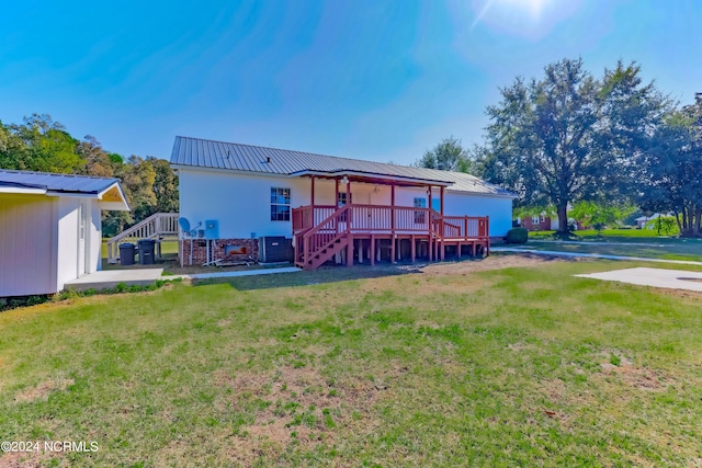 back of property with a wooden deck and a yard