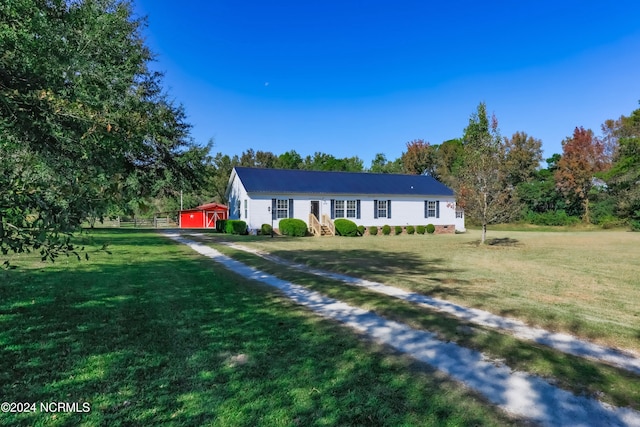 single story home with a storage unit and a front yard