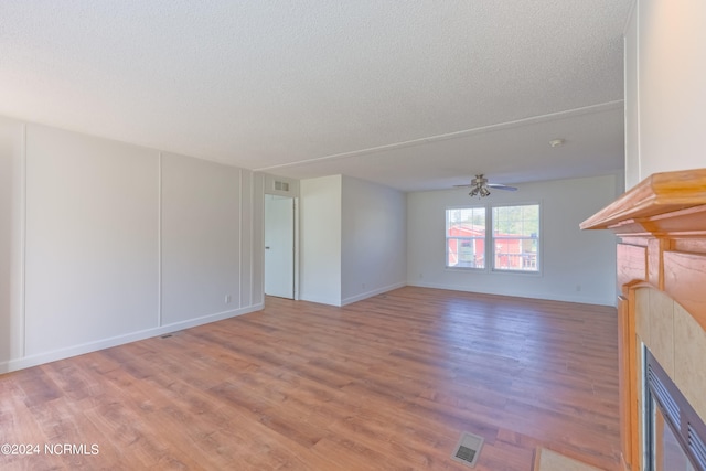 unfurnished living room featuring hardwood / wood-style floors, a textured ceiling, and ceiling fan