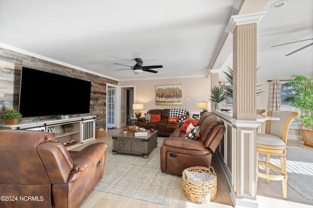 living room featuring light hardwood / wood-style flooring, ornate columns, ceiling fan, and ornamental molding