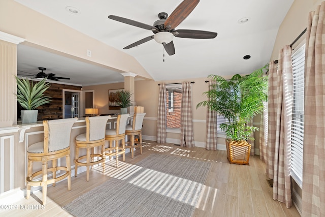 interior space with light hardwood / wood-style floors, decorative columns, ornamental molding, and ceiling fan