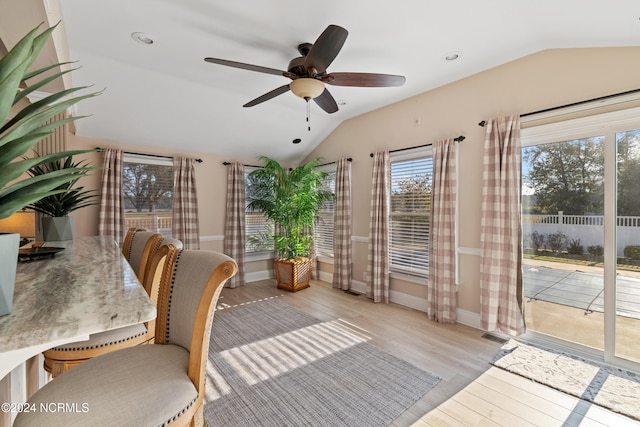 unfurnished dining area with ceiling fan, lofted ceiling, and light wood-type flooring