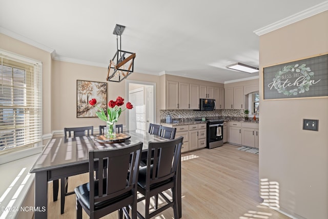 dining space with a chandelier, light wood-type flooring, and ornamental molding