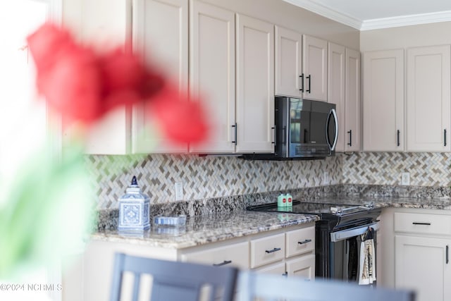 kitchen featuring light stone counters, backsplash, appliances with stainless steel finishes, white cabinets, and ornamental molding