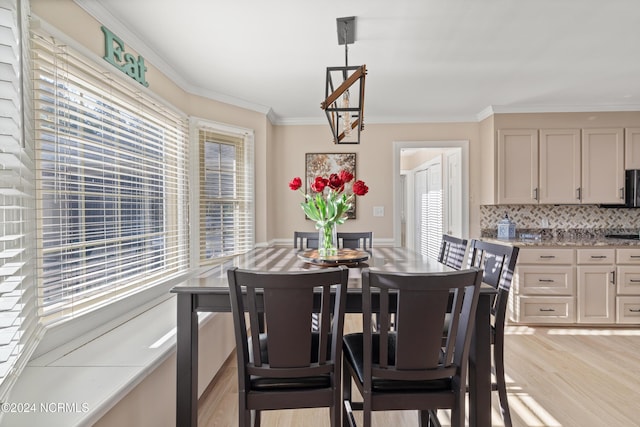 dining room featuring light wood-type flooring and crown molding