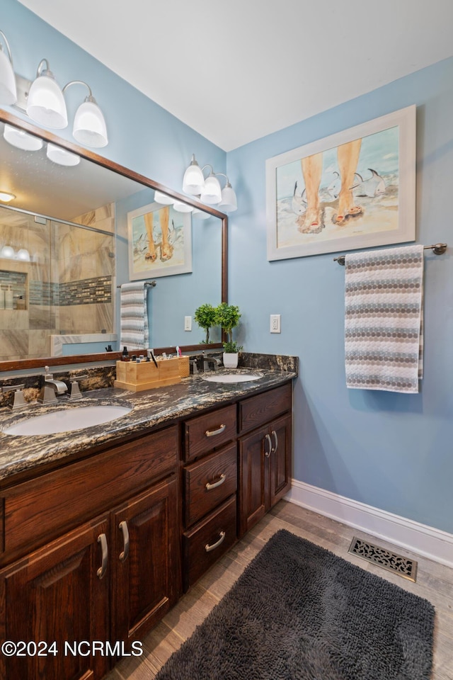 bathroom with walk in shower, vanity, and hardwood / wood-style flooring