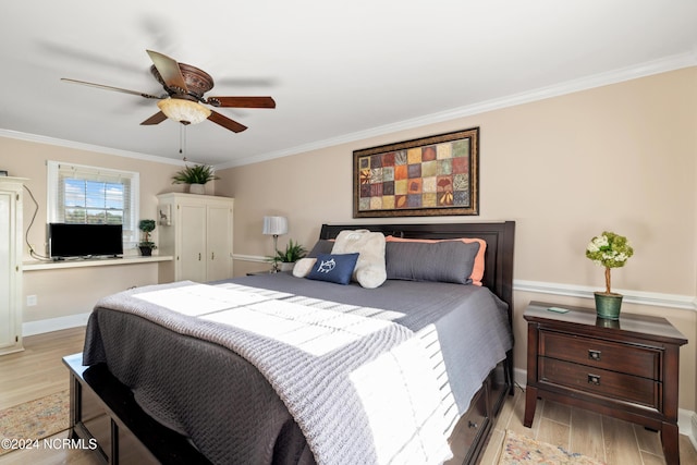 bedroom featuring ceiling fan, light wood-type flooring, and crown molding