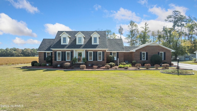 cape cod house featuring a front yard