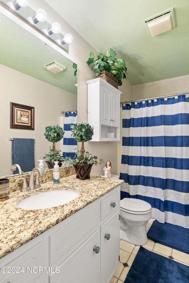 bathroom with tile patterned flooring, vanity, and toilet