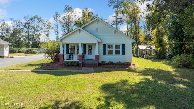 view of front facade with a playground, a porch, and a front yard