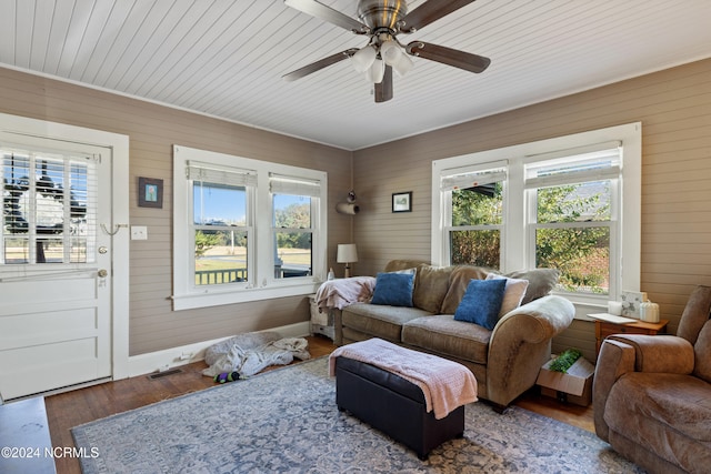 living room featuring ceiling fan, wood walls, wood-type flooring, and wooden ceiling