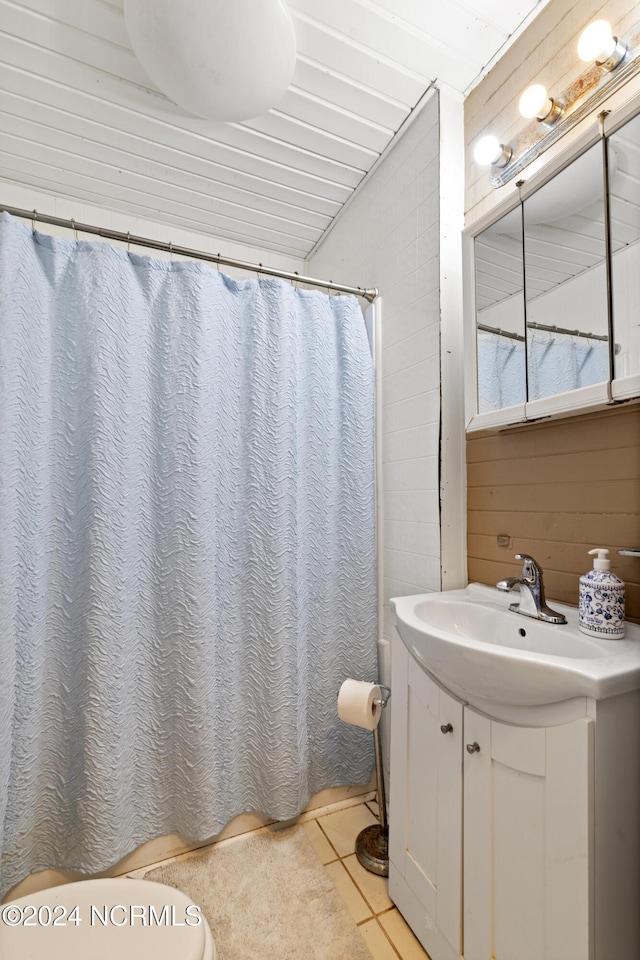 bathroom featuring vanity, tile patterned floors, curtained shower, and wood walls