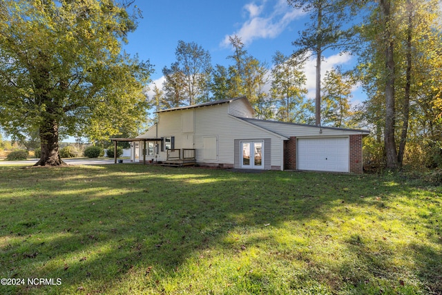 back of house featuring french doors, a yard, and a garage