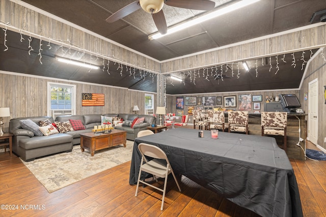 recreation room with wood walls, lofted ceiling, and hardwood / wood-style flooring