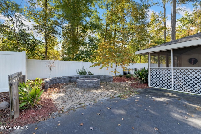 view of patio / terrace with a sunroom and an outdoor fire pit