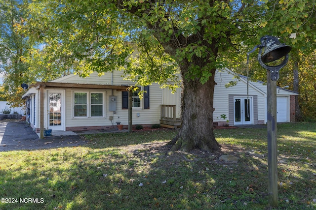 view of front of house featuring a front yard and french doors