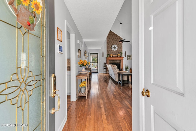 hallway with a textured ceiling and wood-type flooring