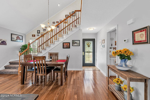 dining space featuring crown molding, a notable chandelier, lofted ceiling, and hardwood / wood-style floors