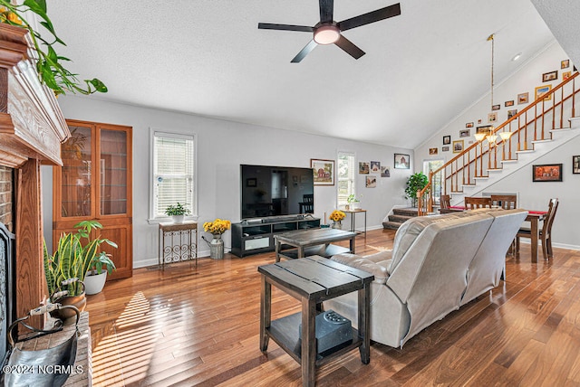 living room with lofted ceiling, a textured ceiling, hardwood / wood-style flooring, and ceiling fan