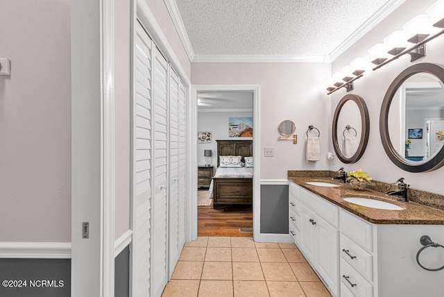 bathroom with vanity, crown molding, tile patterned floors, and a textured ceiling