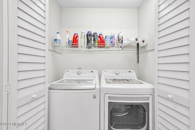 washroom featuring a textured ceiling and washer and clothes dryer