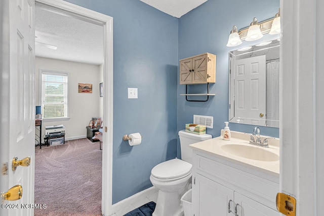 bathroom with vanity, a textured ceiling, and toilet