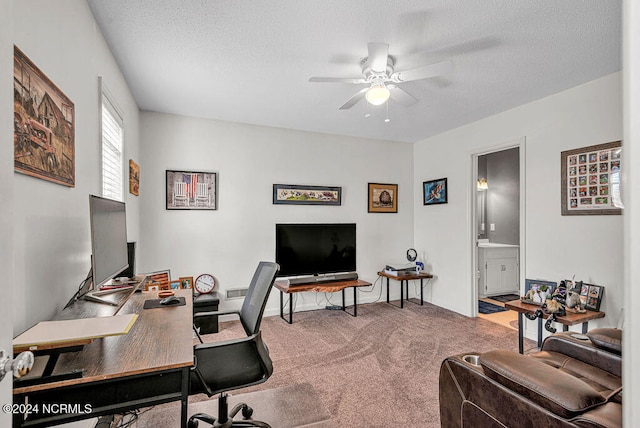 office featuring a textured ceiling, carpet flooring, and ceiling fan