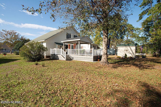 rear view of house with covered porch and a lawn