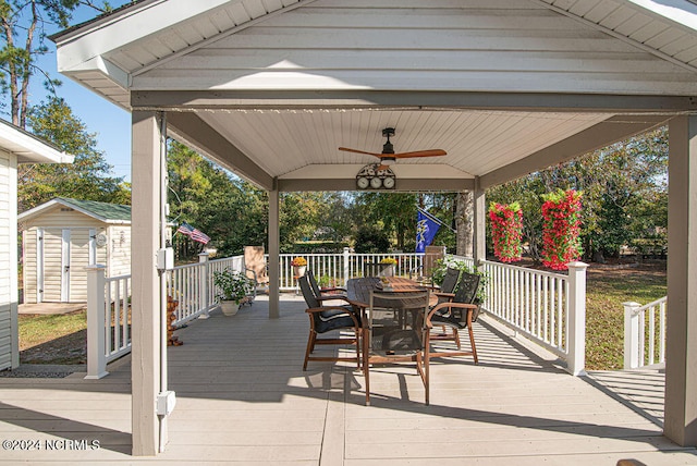 wooden deck with an outbuilding and ceiling fan