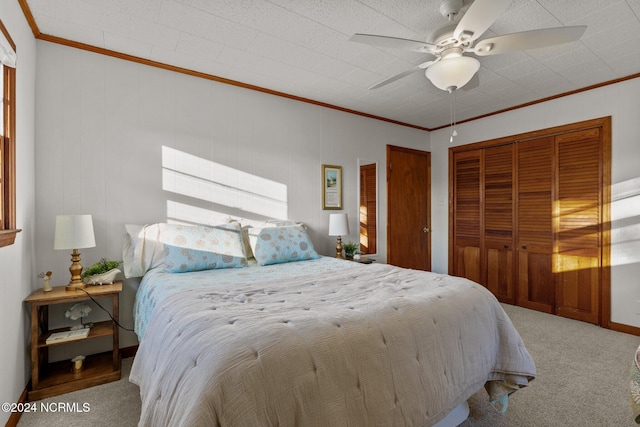 carpeted bedroom with a closet, ceiling fan, crown molding, and a textured ceiling