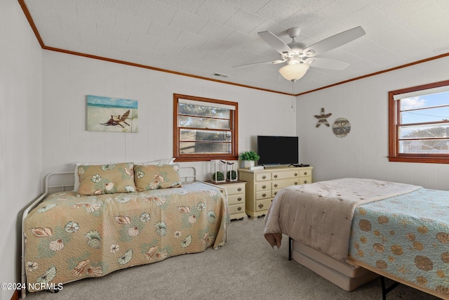 carpeted bedroom featuring crown molding and ceiling fan