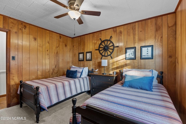 bedroom with ceiling fan, carpet floors, and wooden walls