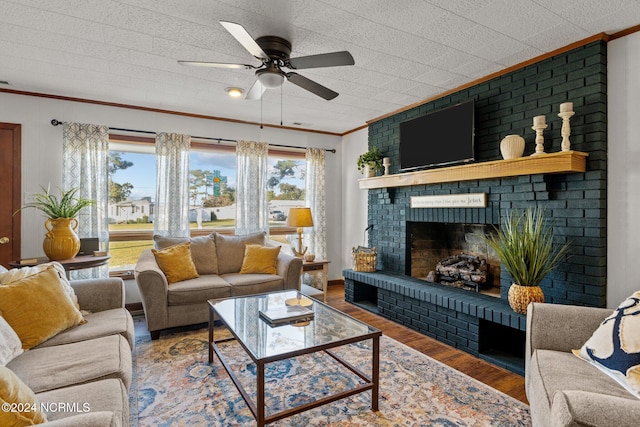 living room featuring ornamental molding, a fireplace, wood-type flooring, and plenty of natural light