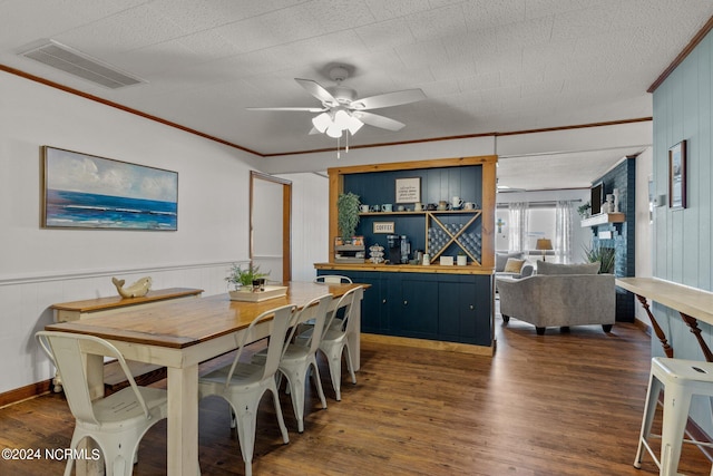 dining space with ceiling fan, dark hardwood / wood-style flooring, a textured ceiling, ornamental molding, and wooden walls