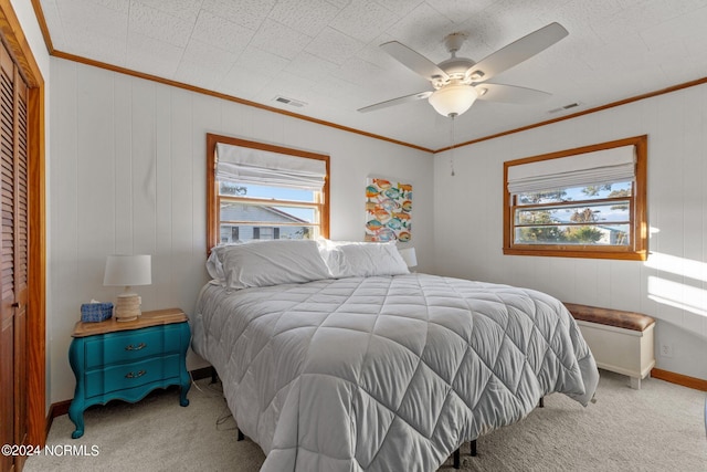 carpeted bedroom with crown molding, multiple windows, a closet, and ceiling fan