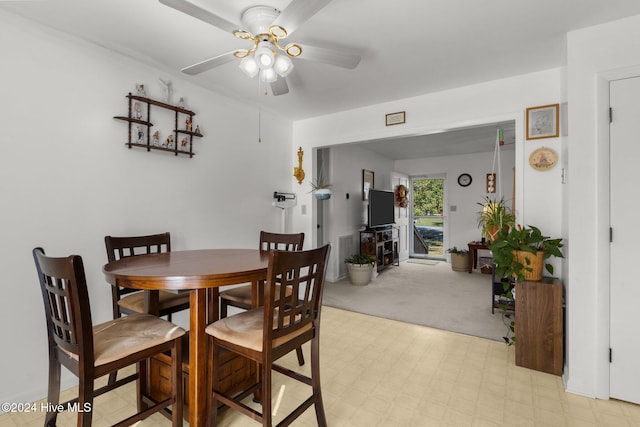 dining area with light carpet and ceiling fan