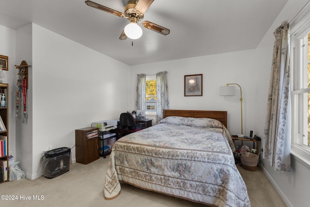 bedroom featuring light colored carpet and ceiling fan