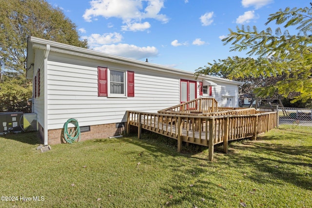 back of property with a yard and a wooden deck